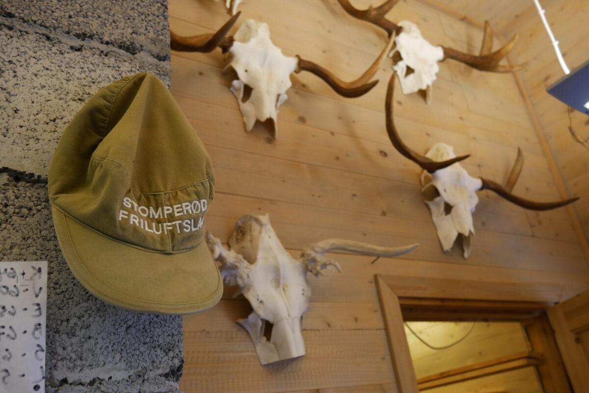 Bilde av vegg på stua med caps og gevir hengende til pynt.