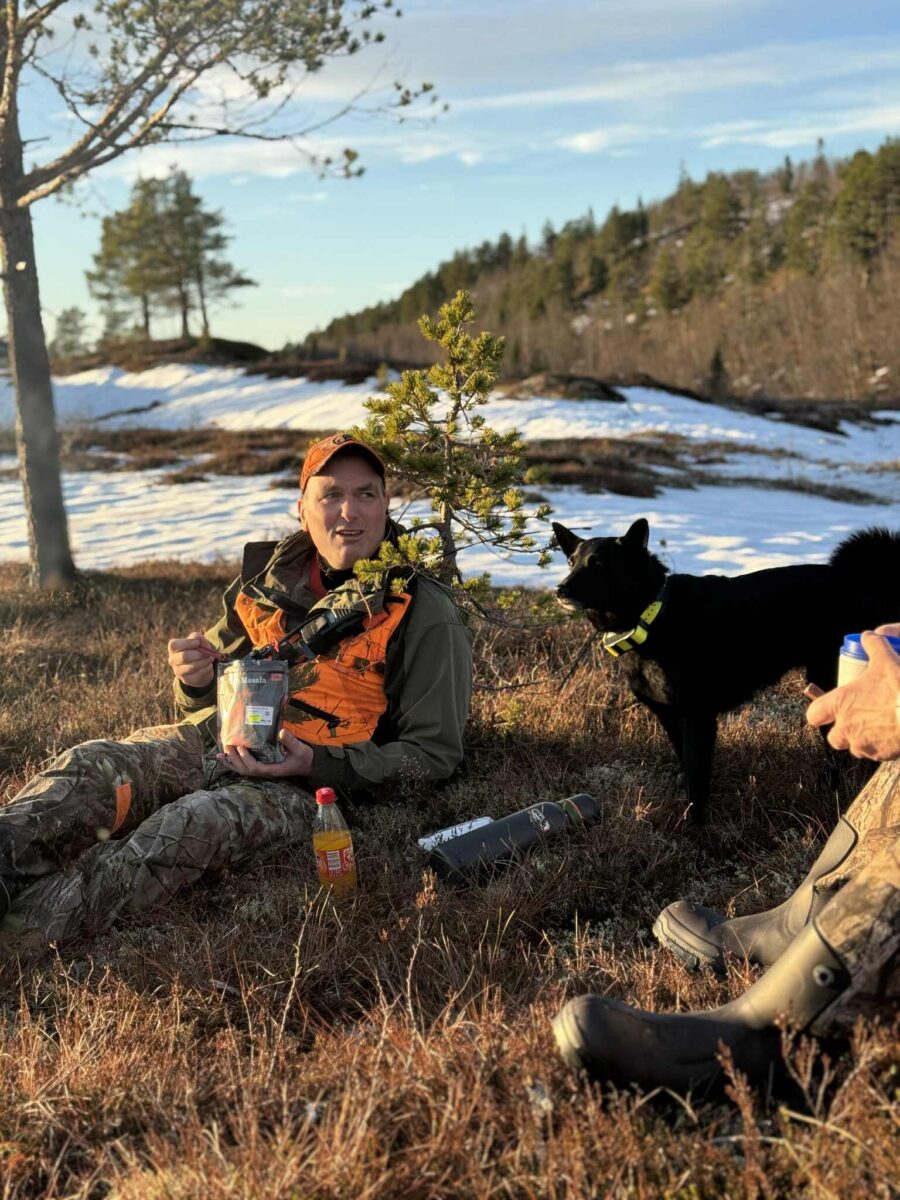 Bilde av Roger Meås og elghunden Akira ute i naturen.