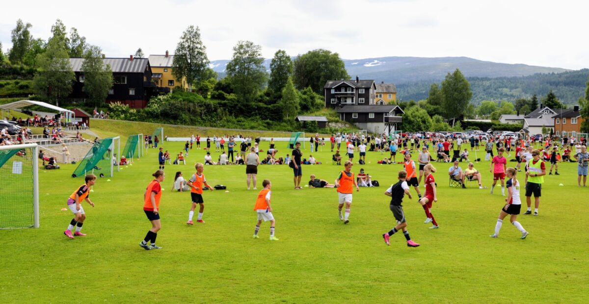 Mange barn og unge som spiller fotball på en fotballbane