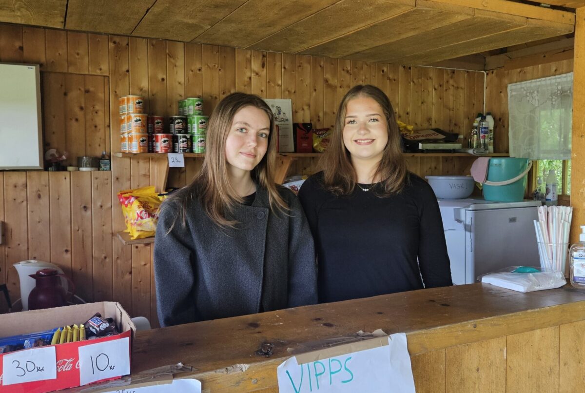 To jenter står i en kiosk