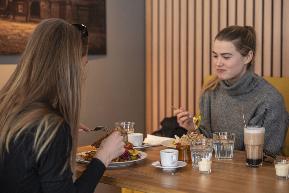 To kvinnelige gjester som spiser lunsj hos 3 Venner Kafé